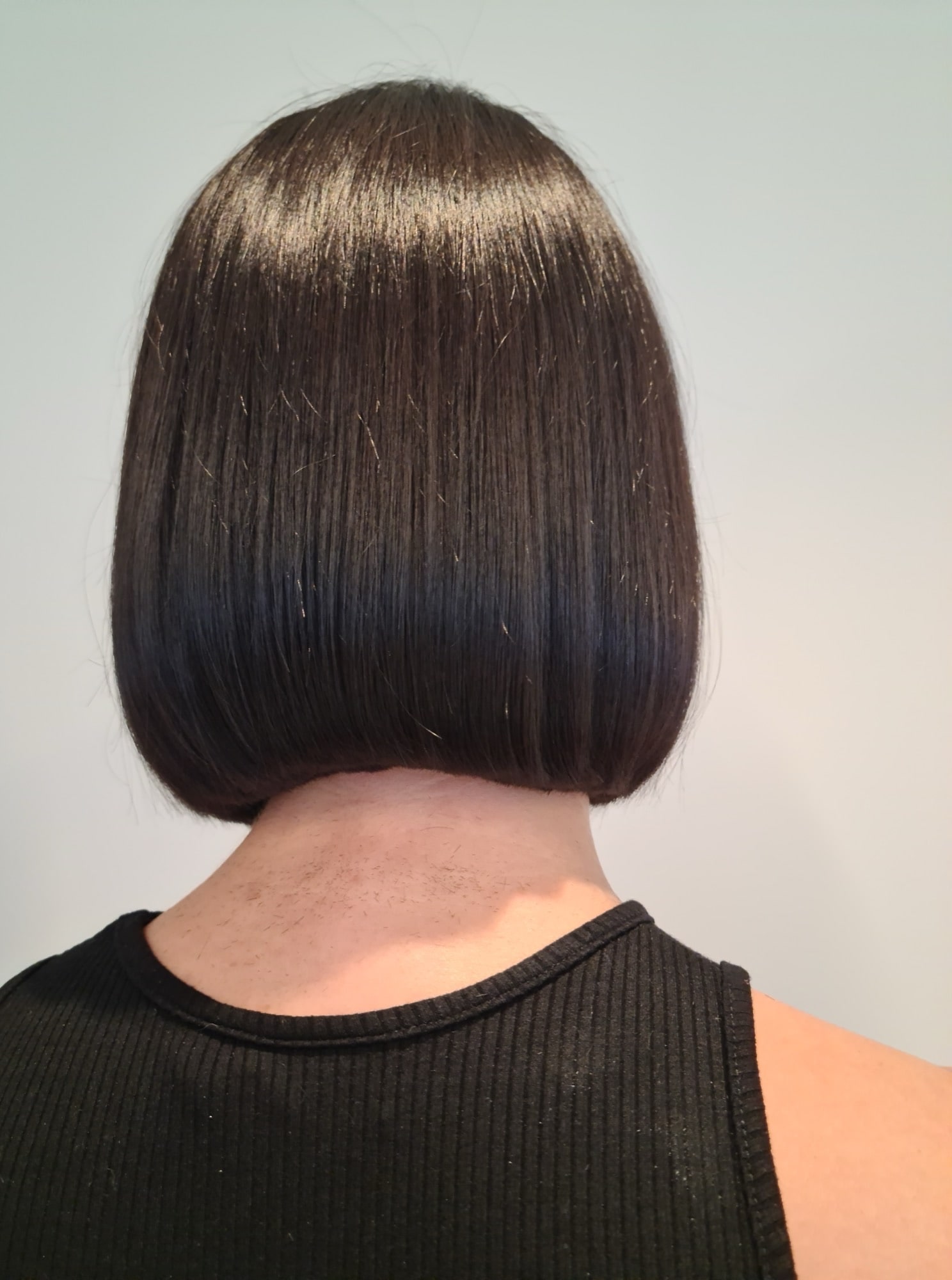 back of woman's head, she has a bob haircut and dark hair