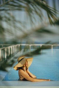 lady with a hat on around the pool