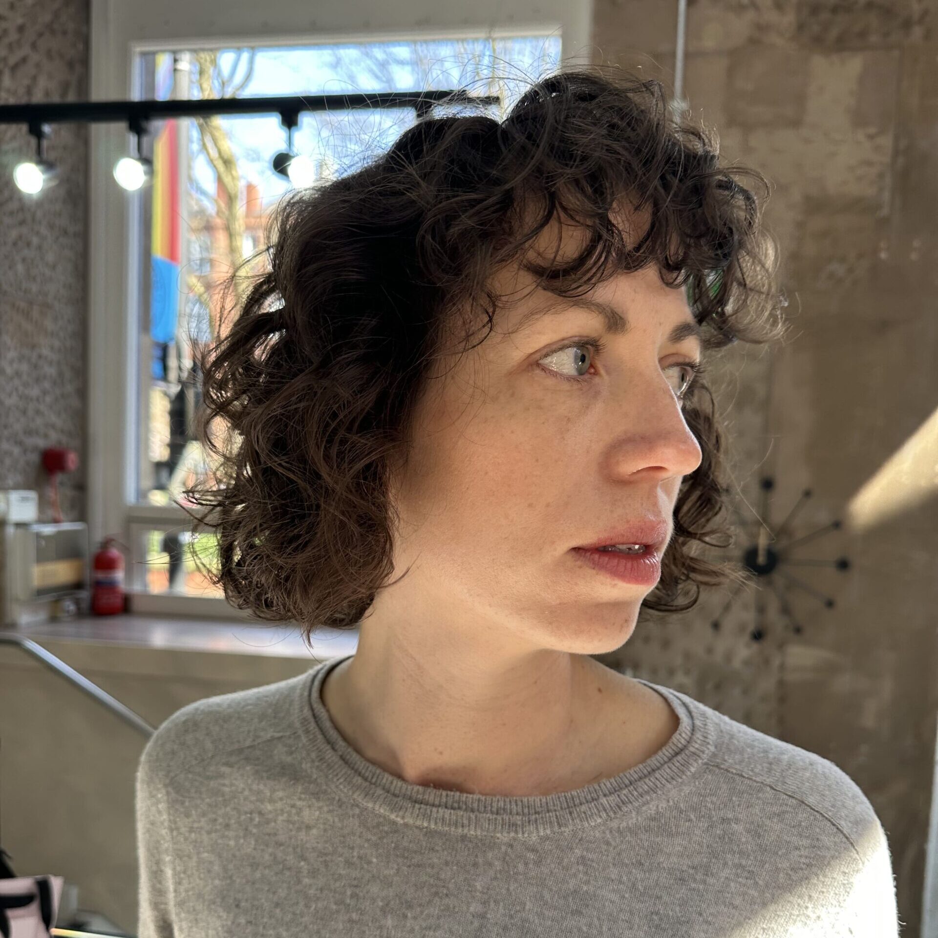 side profile of a woman with short curly hair