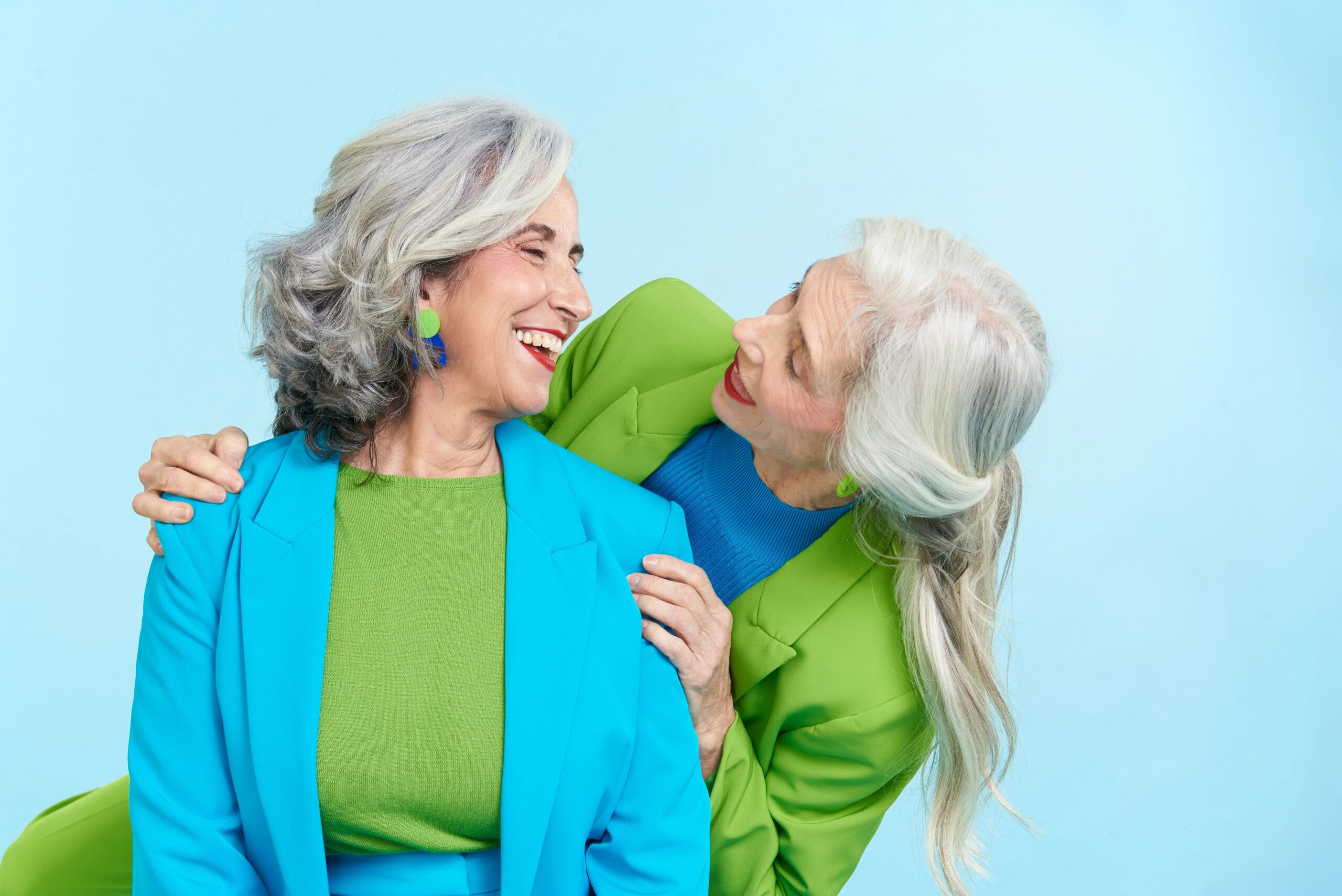 two ladies with grey hair hugging