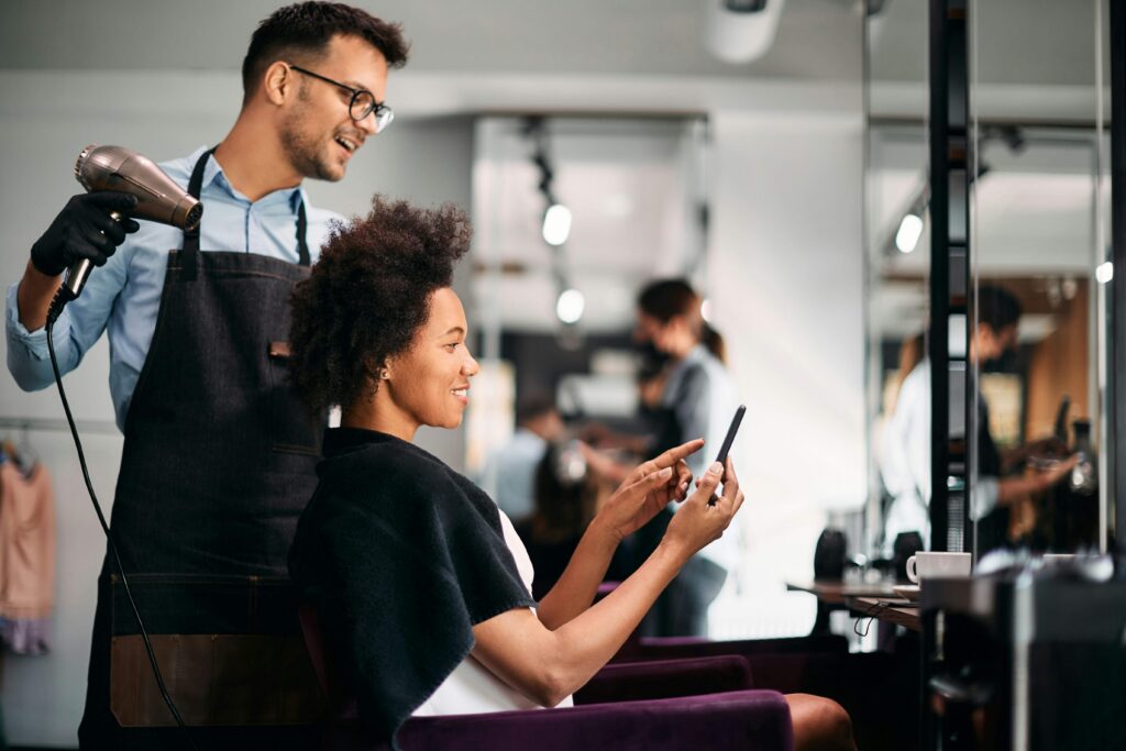 a man doing a lady's hair  in a hair salon