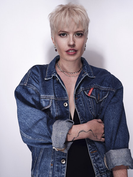 lady in denim jacket posing for the camera with her short textured haircut