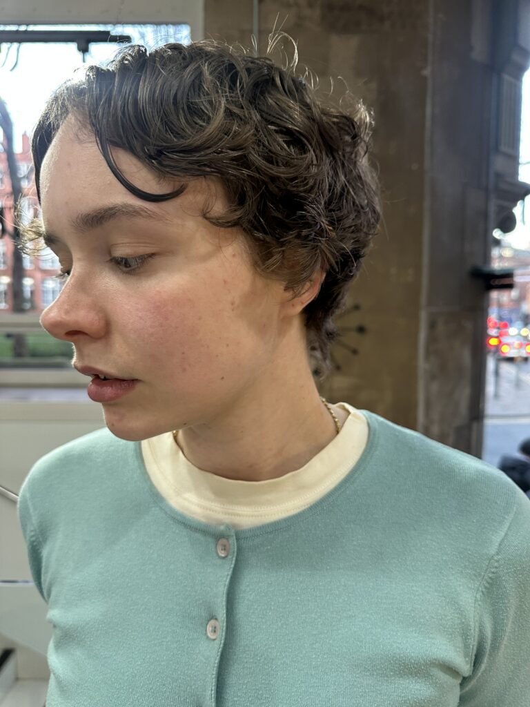 lady in blue cardigan with curly short hair