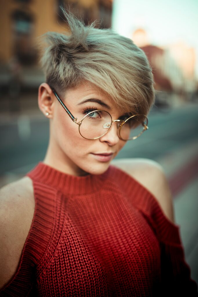 lady in glasses with short hair going longer to one side