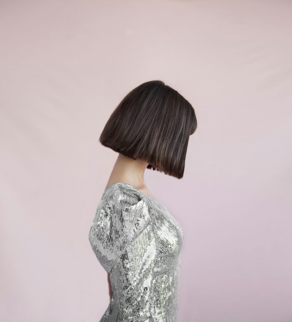 lady in silver top showing off her one length bob